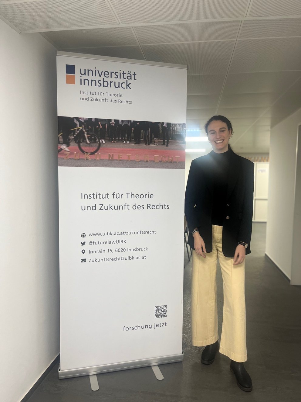 Silvia Corradi steht vor einem Roll-up des Instituts