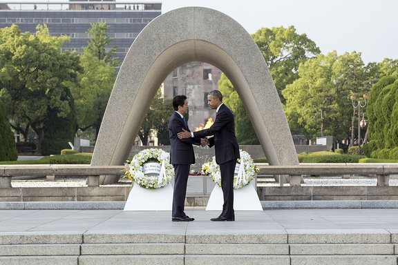 Präsident Obama und der japanische Premierminister Shinzo Abe schütteln sich im Mai 2016 die Hände, nachdem sie in einer Zeremonie am Hiroshima-Friedensdenkmal in Hiroshima, Japan, Kränze niedergelegt haben.
