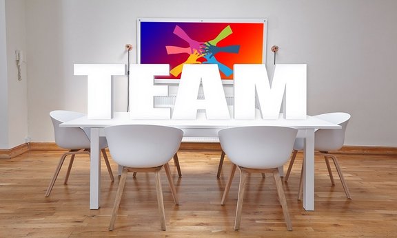 Sitzungszimmer, das Wort "Team" in Großbuchstaben auf dem Tisch platziert