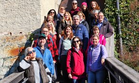 Zahlreiche Personen in Wanderkleidung stehen auf einer hölzernen Brücke.