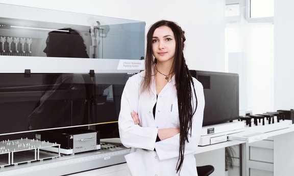 Chiara Herzog mit weißem Laborkittel in einem Labor