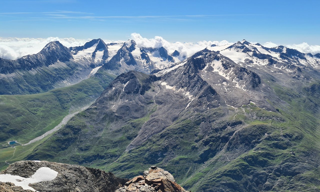 Bergpanorama mit schneebedeckten Bergspitzen und blauem Himmel