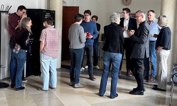 Menschen beim Kaffeeautomat im Gespräch