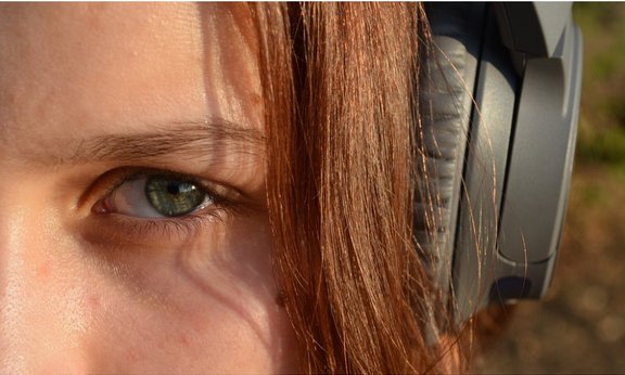 Gesicht einer Frau mit Kopfhörer, nur zum Teil sichtbar