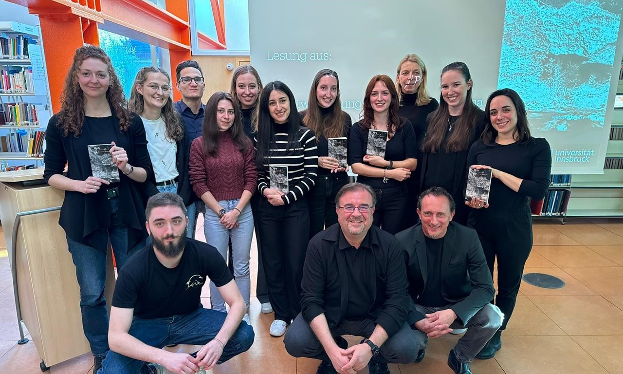 Gruppenfoto mit mehreren Personen, einige davon halten das präsentierte Buch.