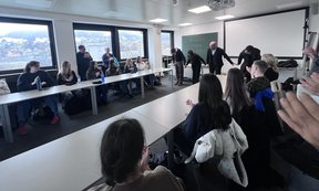 Teilnehmer:innen in Seminarraum, vorne Schauspieler:innen, die sich verbeugen