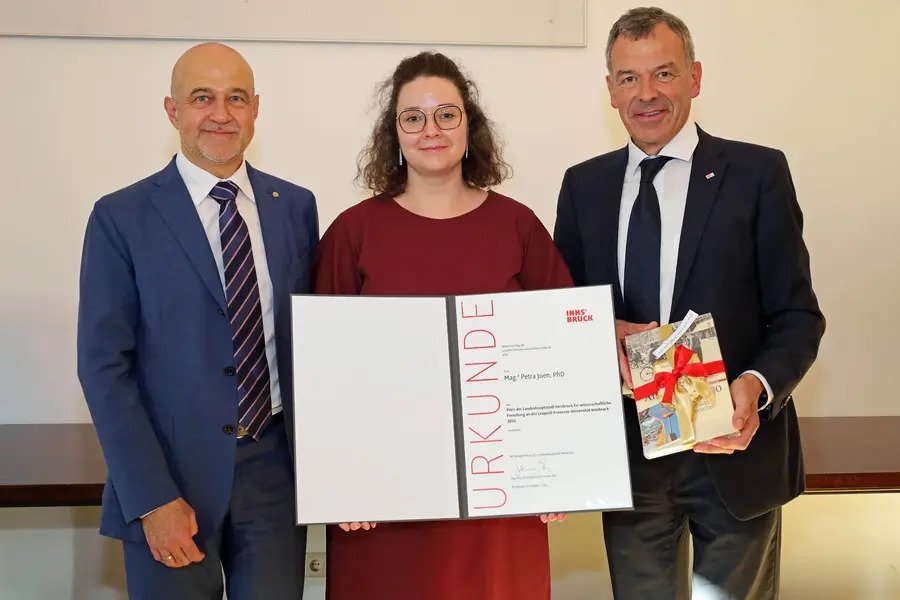 zu sehen ist Petra Juen bei Erhalt des Wissenschaftspreises zwischen Vizerektor für Forschung Dr. Gregor Weihs und Vizebürgermeister Georg Willi.