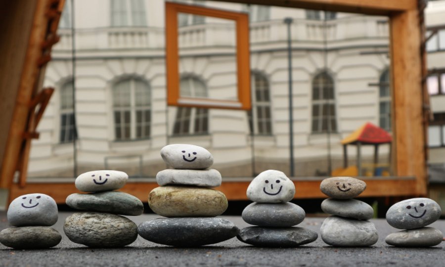 Steinmännchen mit Gesichtern, die vor dem Gebäude der Spielräume aufgestellt sind.
