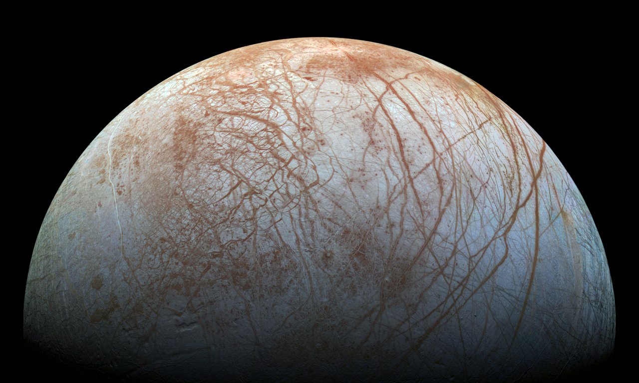Der Jupitermond Europa, eine weiße Hülle mit viele rötlichen Streifen.
