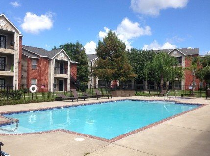 Der türkisblaue Pool des Privateer Place unter strahlend blauem Himmel