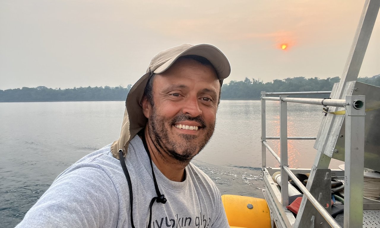 Auf dem Bild zu sehen ist Dr. Jonathan Obrist-Farner sitzend auf einem Schiff.