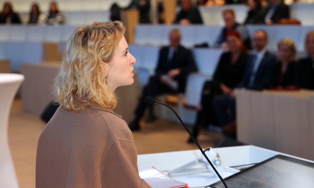 Eva-Maria Holzleitner spricht an einem Podium