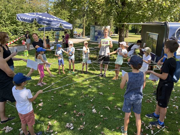 Kinder stehen im Kreis und spielen ein Spiel