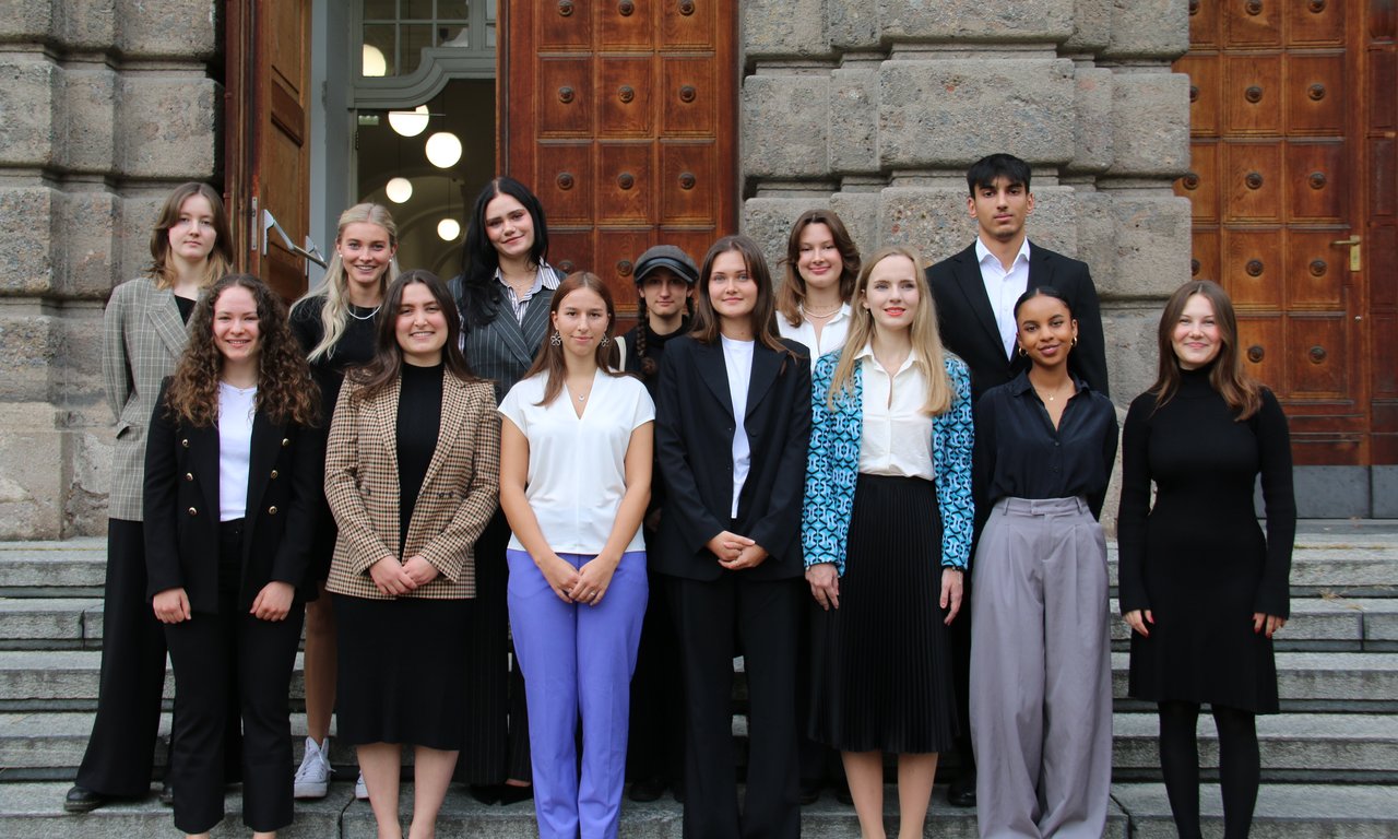 Gruppenfoto vor dem Eingang des Uni-Hauptgebäudes.