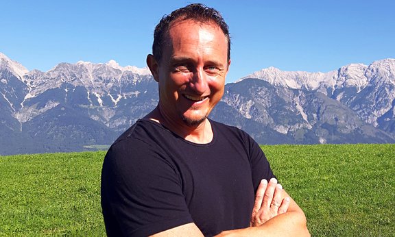 Christian Kössler vor einer Bergkulisse.