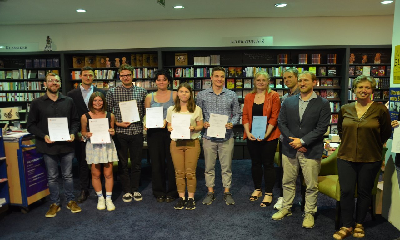 Gruppenfoto mit mehreren Personen in einer Buchhandlung