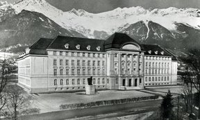 Historische Aufnahme des Hauptgebäudes der Universität mit der Nordkette im Hintergrund.