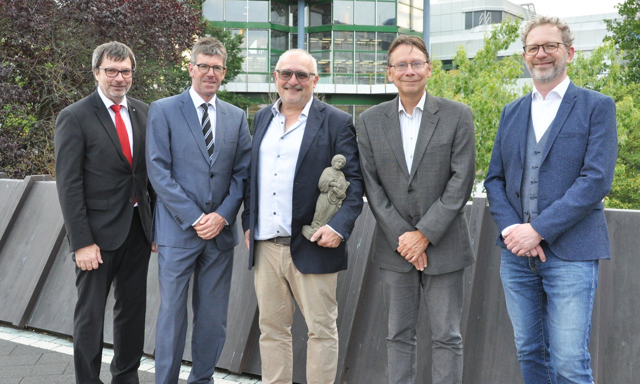 Fünf Männer stehen für ein Gruppenfoto nebeneinander.