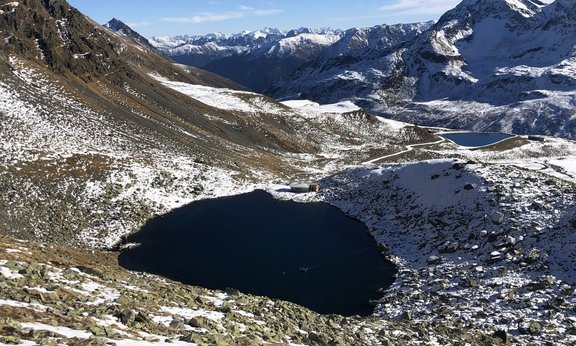 Ein See mit Hütte in verschneiter Berglandschaft