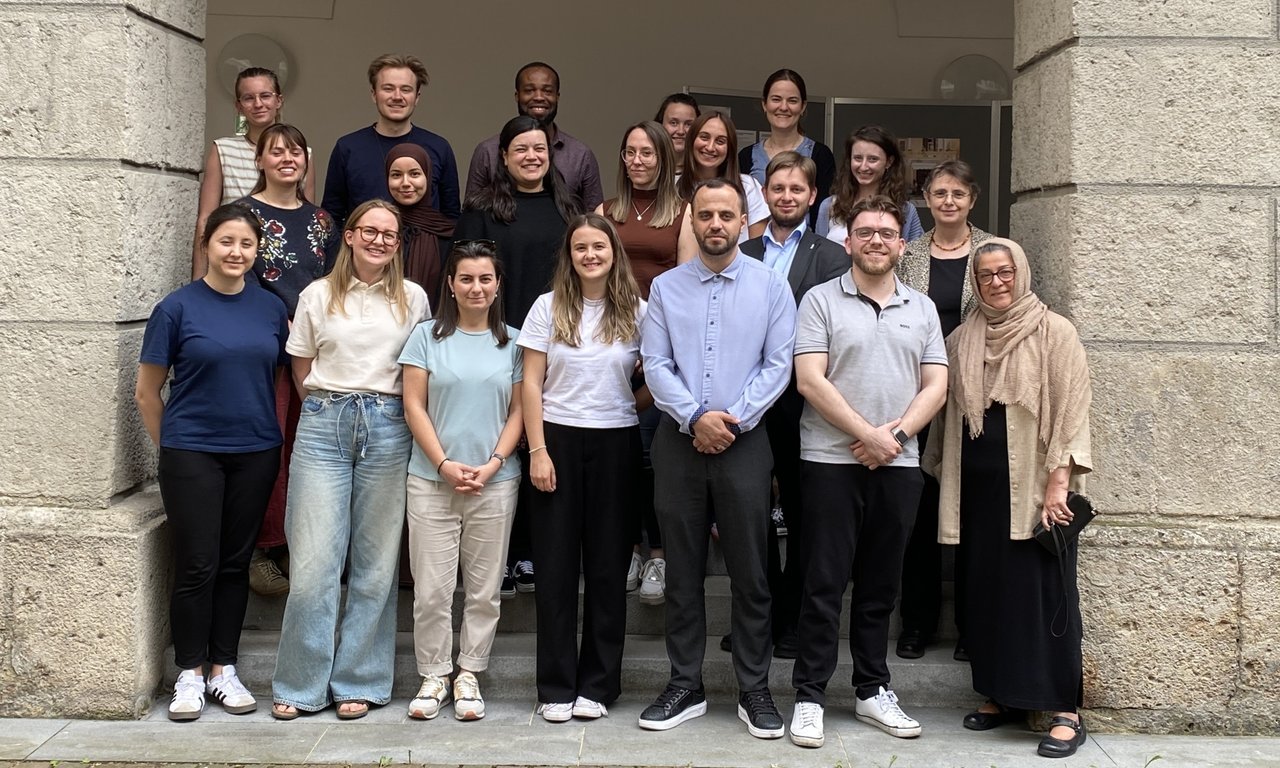 Zu sehen sind die Lehrenden und die Teilnehmer:innen der Lehrveranstaltung. Sie stehen im Freien.
